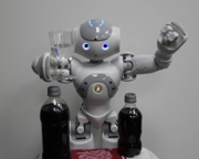 Nao robot places an effervescent antacid in a glass of water.